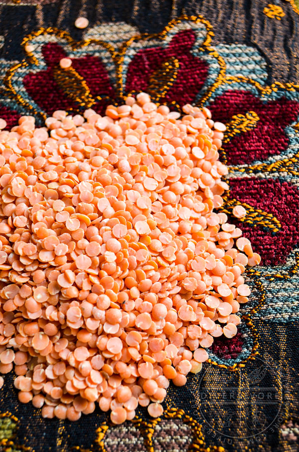 Red lentils scattered on an embroidered placemat
