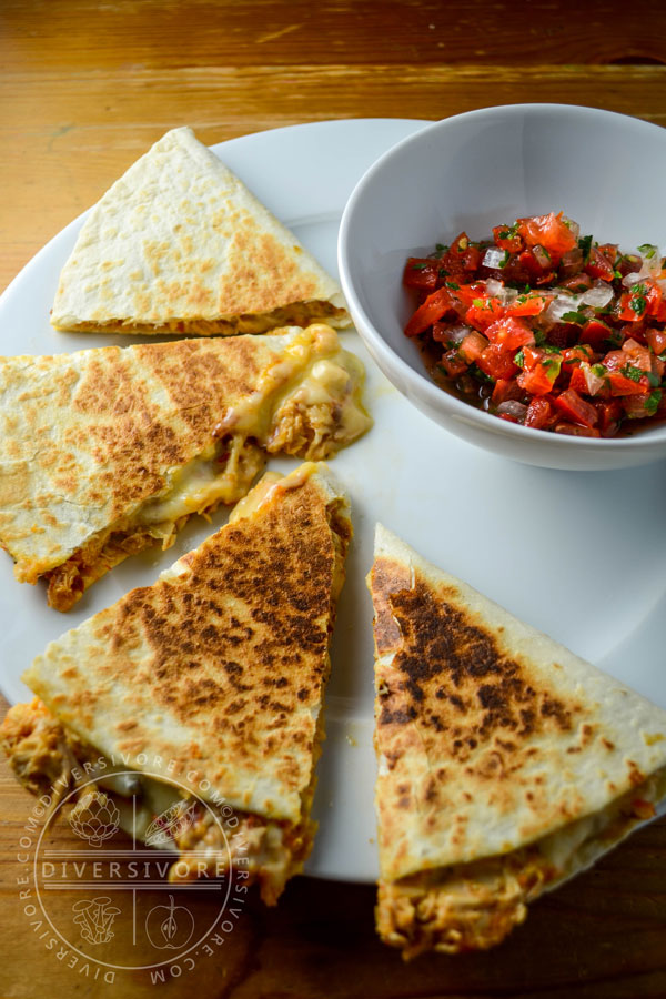 Chicken tinga served in quesadillas with a side of pico de gallo