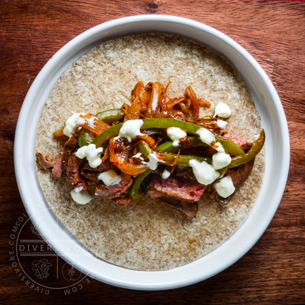 Carne Asada Borracha (Mexican beer-marinated grilled steak) served with Mexican crema and sauteed vegetables, served in a flour tortilla