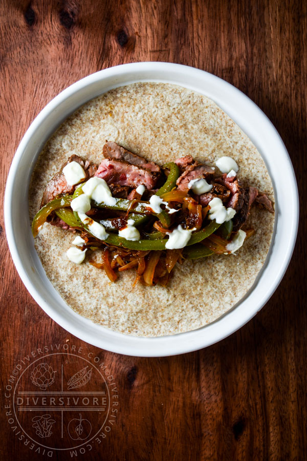 Carne Asada Borracha (Mexican beer-marinated grilled steak) served with Mexican crema and sauteed vegetables, served in a flour tortilla