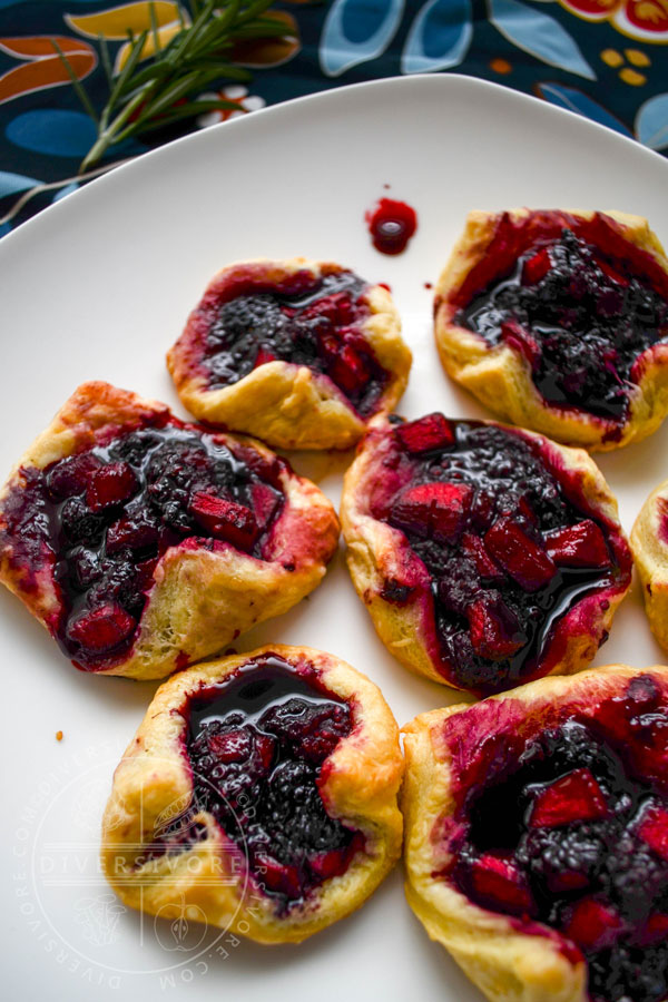 Dewberry and apple puff pastry tarts on a white plate