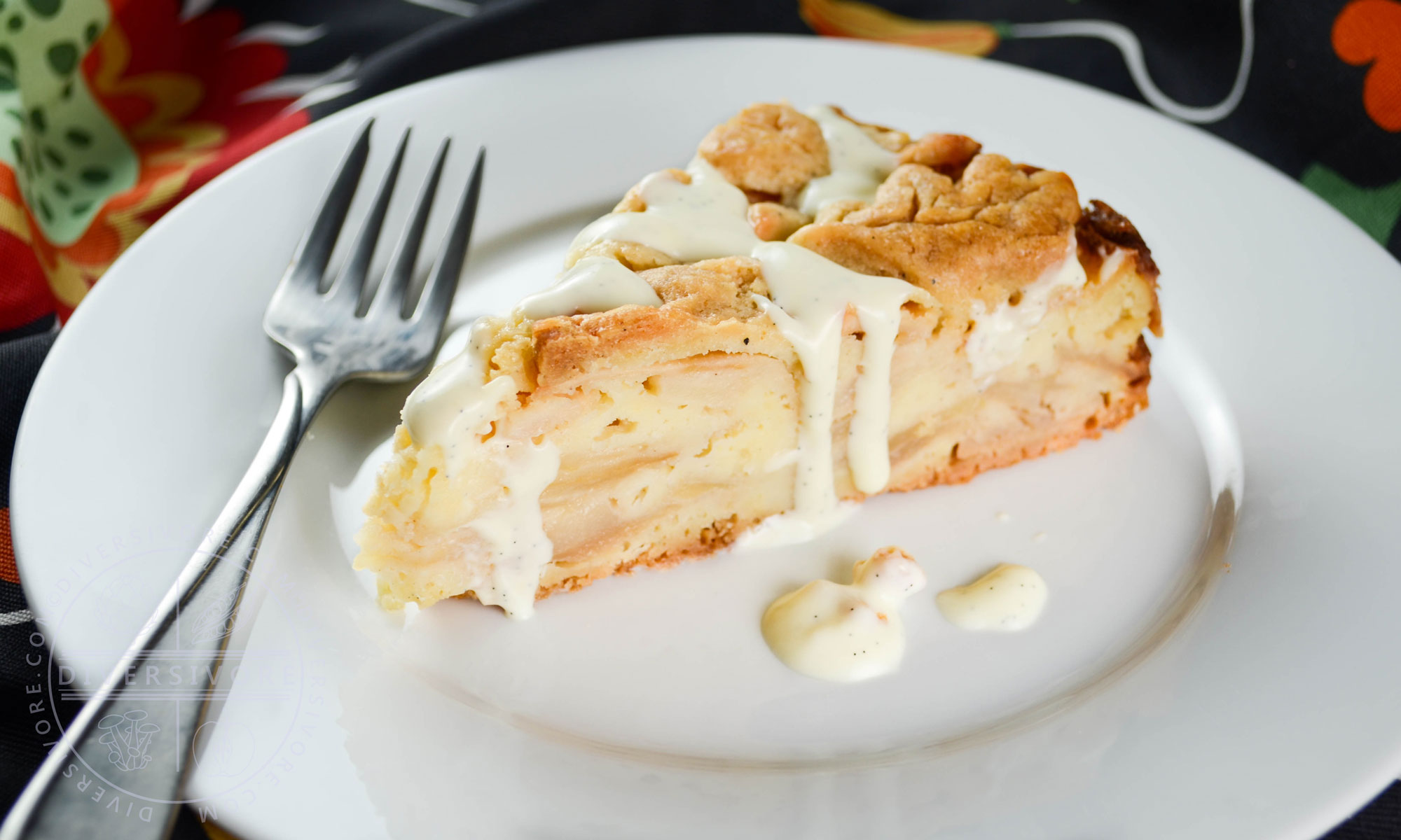 A slice of Swedish apple cake with vanilla sauce on a plate with a fork