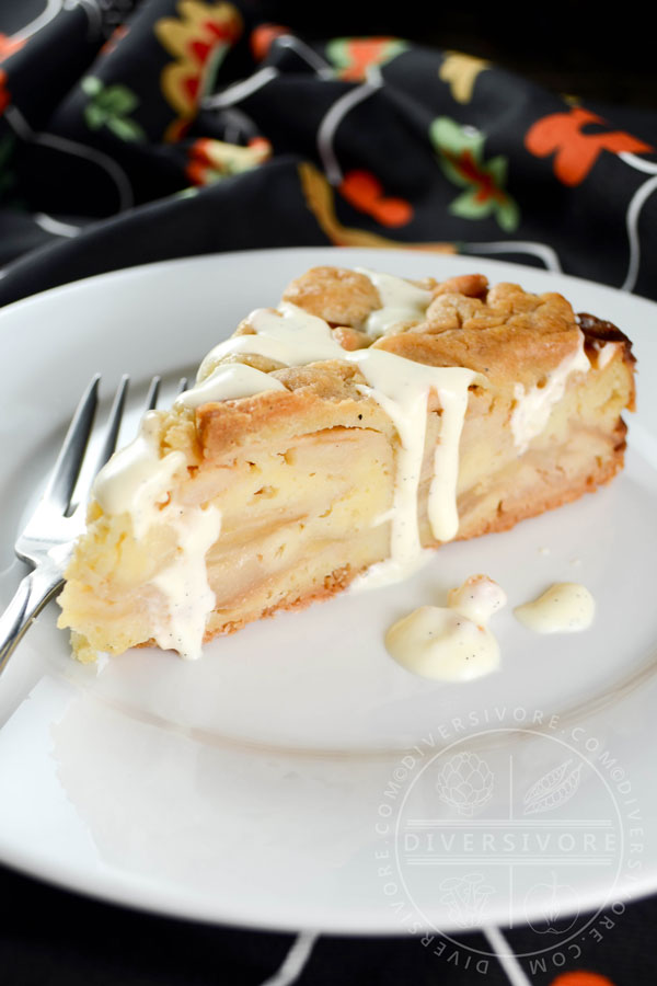 A slice of Swedish apple cake with vanilla sauce on a plate with a fork