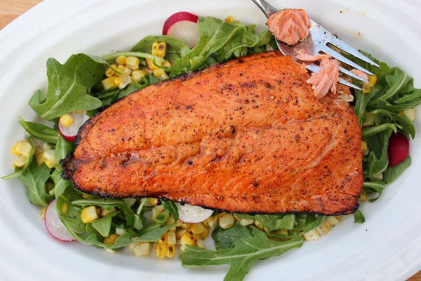 Sweet and spicy grilled salmon on a bed of greens