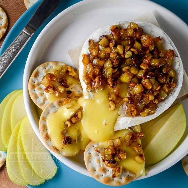 Oozing baked brie, topped with an apple, walnut, and caraway mixture, served with crackers and apple slices