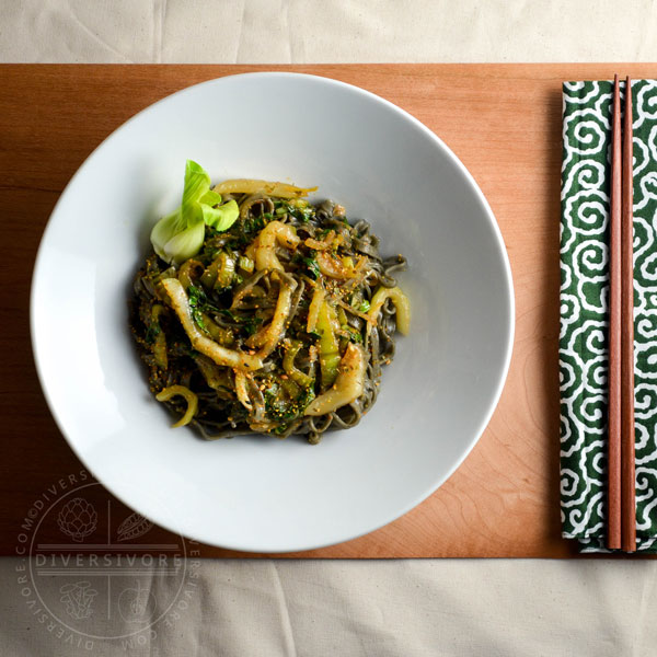 Garlic and lemon bok choy with black sesame noodles in a large white bowl