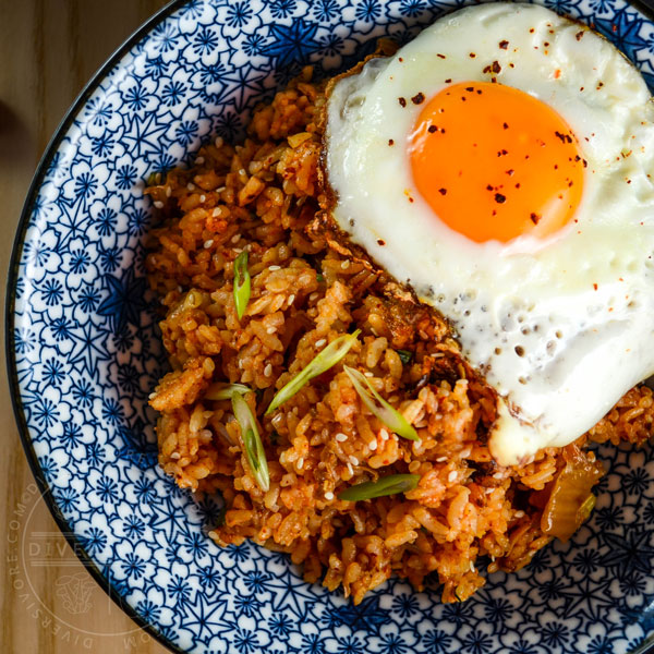 Kimchi fried rice in a blue patterned bowl, topped with a fried egg