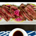 Appetizer portion of beef tataki with ponzu, watermelon radishes, and scallions - Diversivore.com