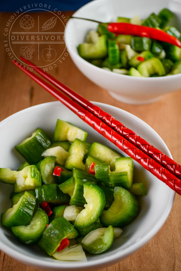 Two bowls of Chinese garlic cucumbers (Liangban Huanggua) with red chopsticks