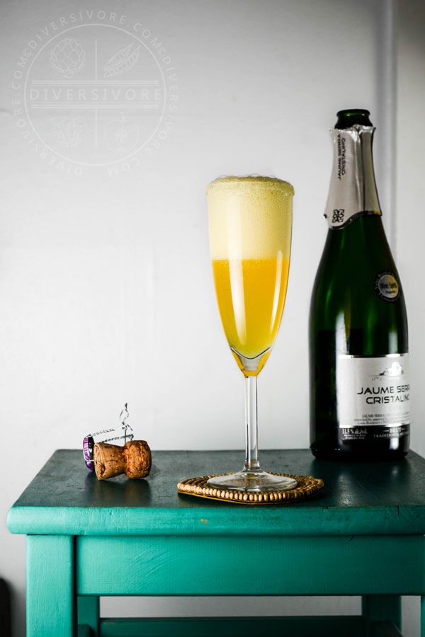 Sparkling Saffron Cocktail with a bottle of cava on a turquoise table