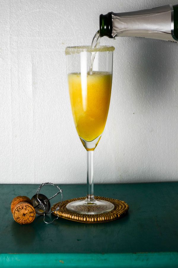 Sparkling Saffron Cocktail with a bottle of cava on a turquoise table