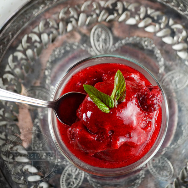 Raspberry Mint Sorbet in a decorative glass on a silver charger plate