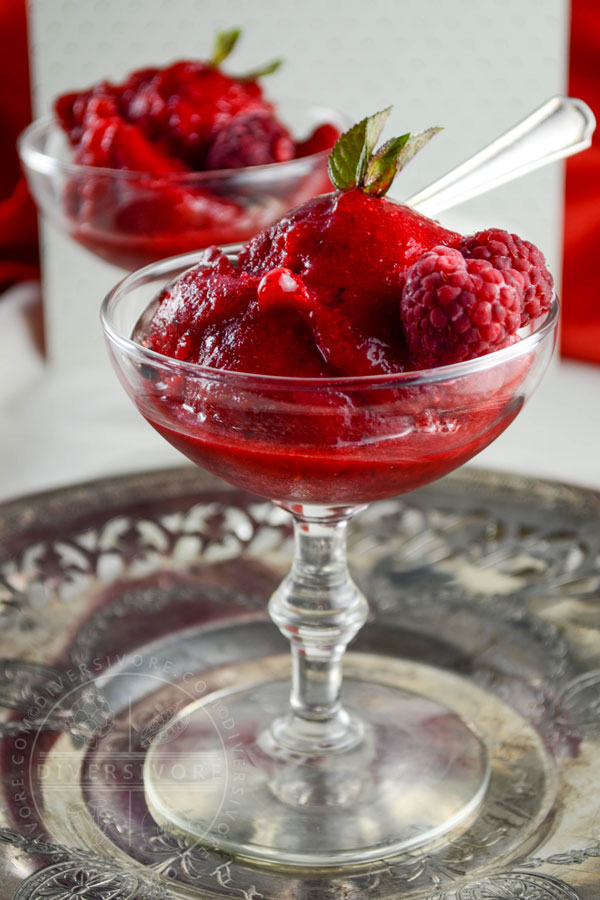 Raspberry Mint Sorbet in a decorative glass on a silver charger plate