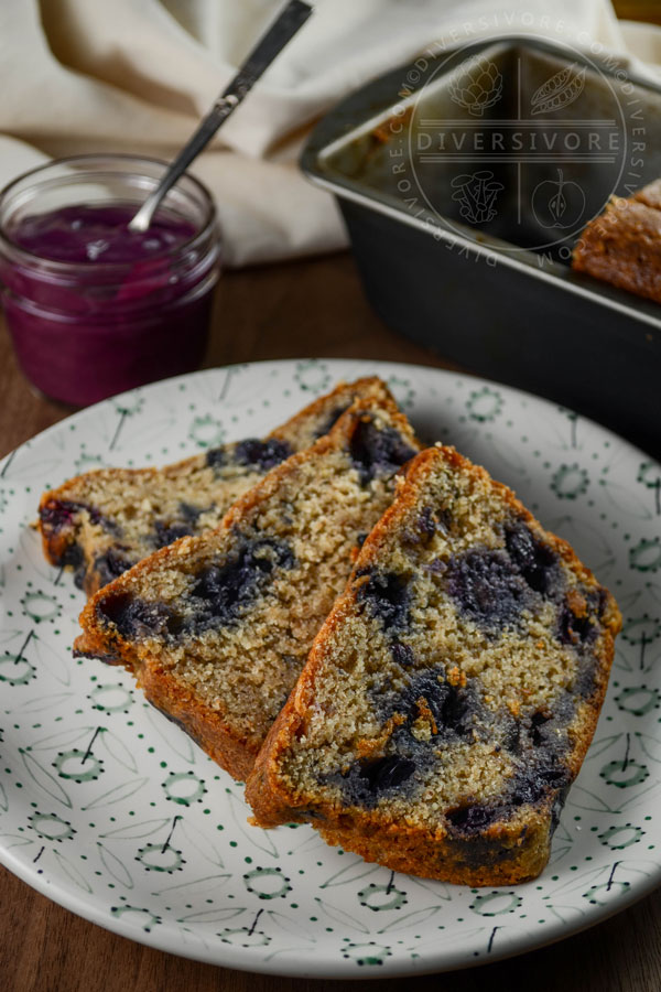 A slice of blueberry juniper rye cake on a small plate with floral decorations
