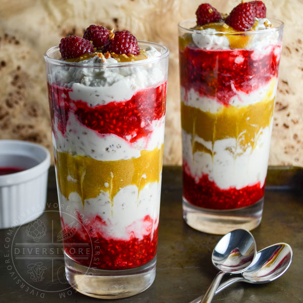 Cranachan with raspberries and greengages in two tall glasses