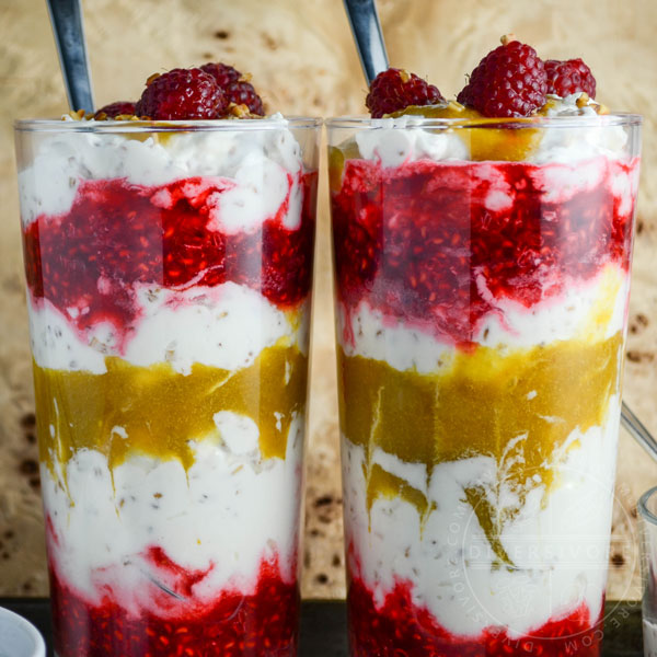 Cranachan with raspberries and greengages in two tall glasses