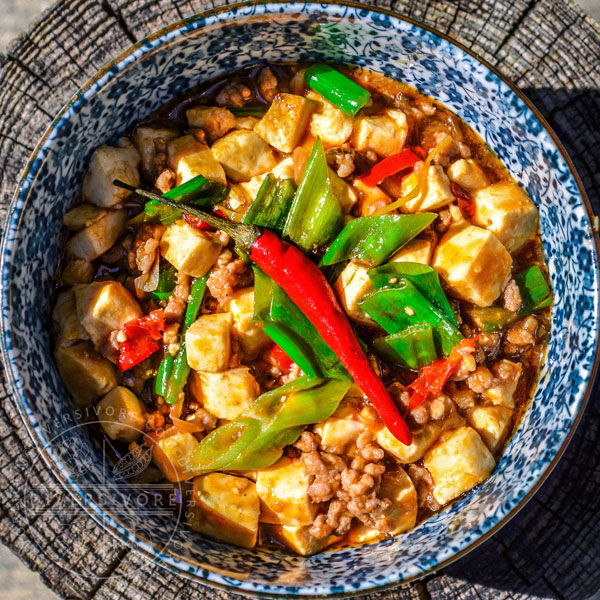 Mapo tofu in a blue and white bowl on a wooden backdrop