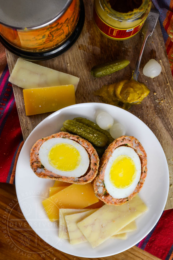 West Coast scotch eggs made with salmon sausage, served with cheese, pickles, and mustard