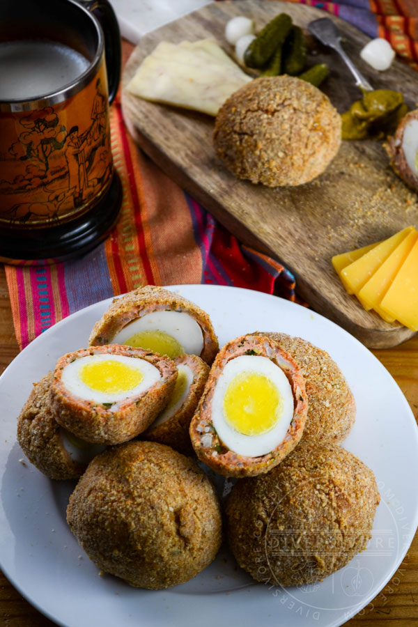 West Coast scotch eggs made with salmon sausage, served with cheese, pickles, and mustard