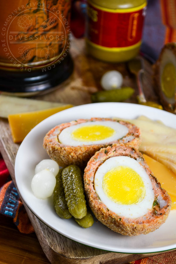 West Coast scotch eggs made with salmon sausage, served with cheese, pickles, and mustard