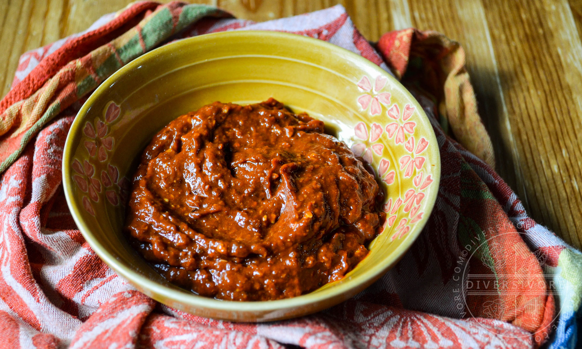 K'uut Bi Ik (Dried Chili Salsa) made with morita chipotles in a small yellow bowl on a bunched up patterned cloth