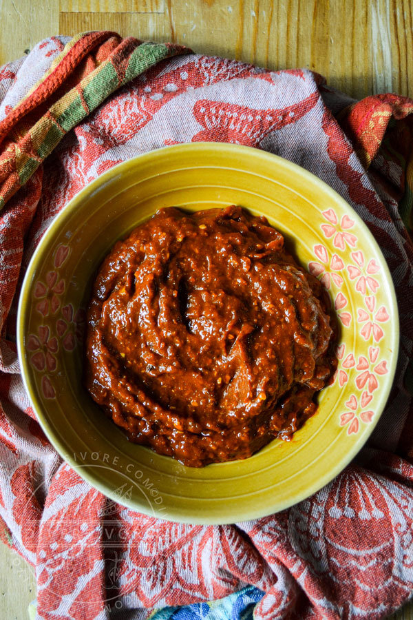 K'uut Bi Ik (Dried Chili Salsa) made with morita chipotles in a small yellow bowl on a bunched up patterned cloth