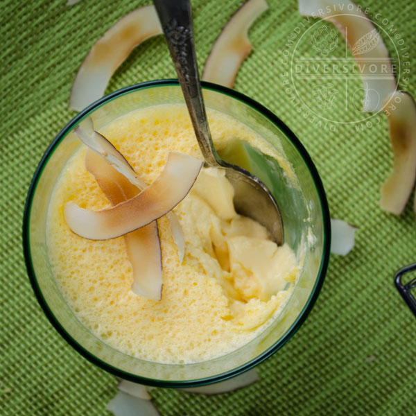 Dairy-free Coconut Lime Mousse in a glass with a silver spoon, topped with toasted coconut