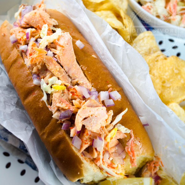 Salmon Guédille with coleslaw in a lobster roll bun, served with chips