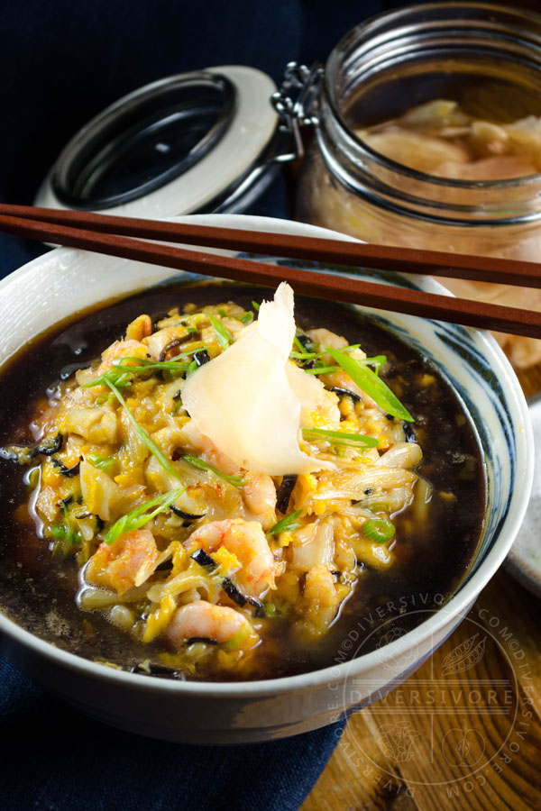 Tenshindon - A Japanese/Chinese crab and shrimp omelette served over rice and topped with a sweet and sour sauce, served in a large bowl and topped with pickled ginger and a pair of chopsticks