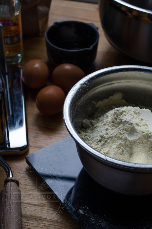 Flour, eggs, and other ingredients and implements for making Chinese egg noodles.