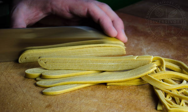 Hand-cutting Chinese egg noodles.