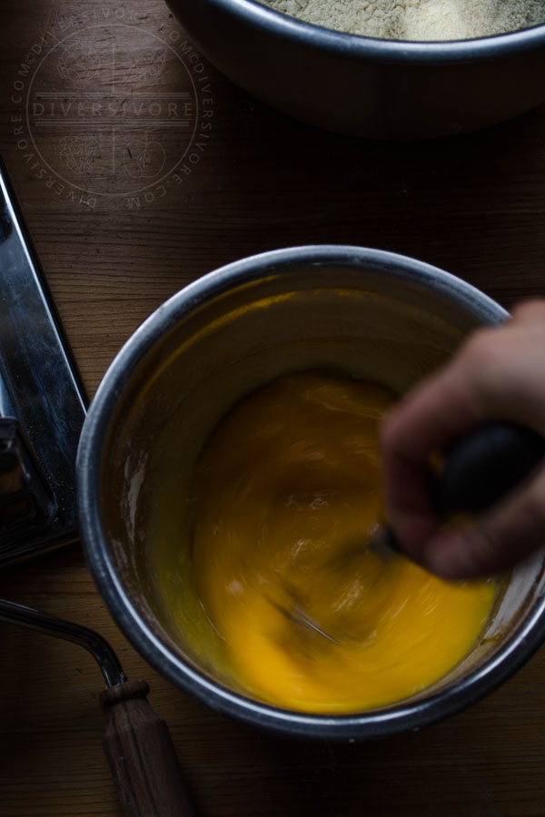 A bowl of eggs being whisked together rapidly.