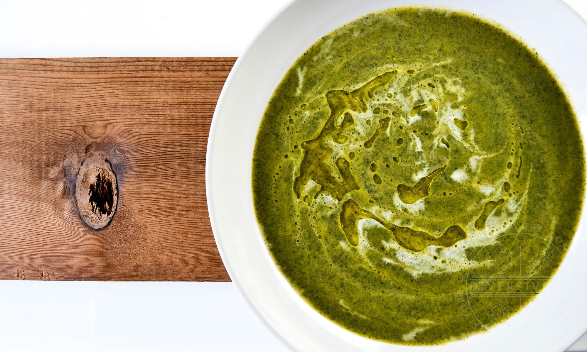 Nettle Cream Soup in a large white bowl on a wooden backdrop