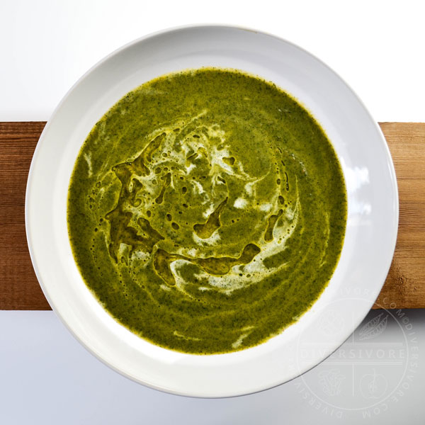 Nettle Cream Soup in a large white bowl on a wooden backdrop