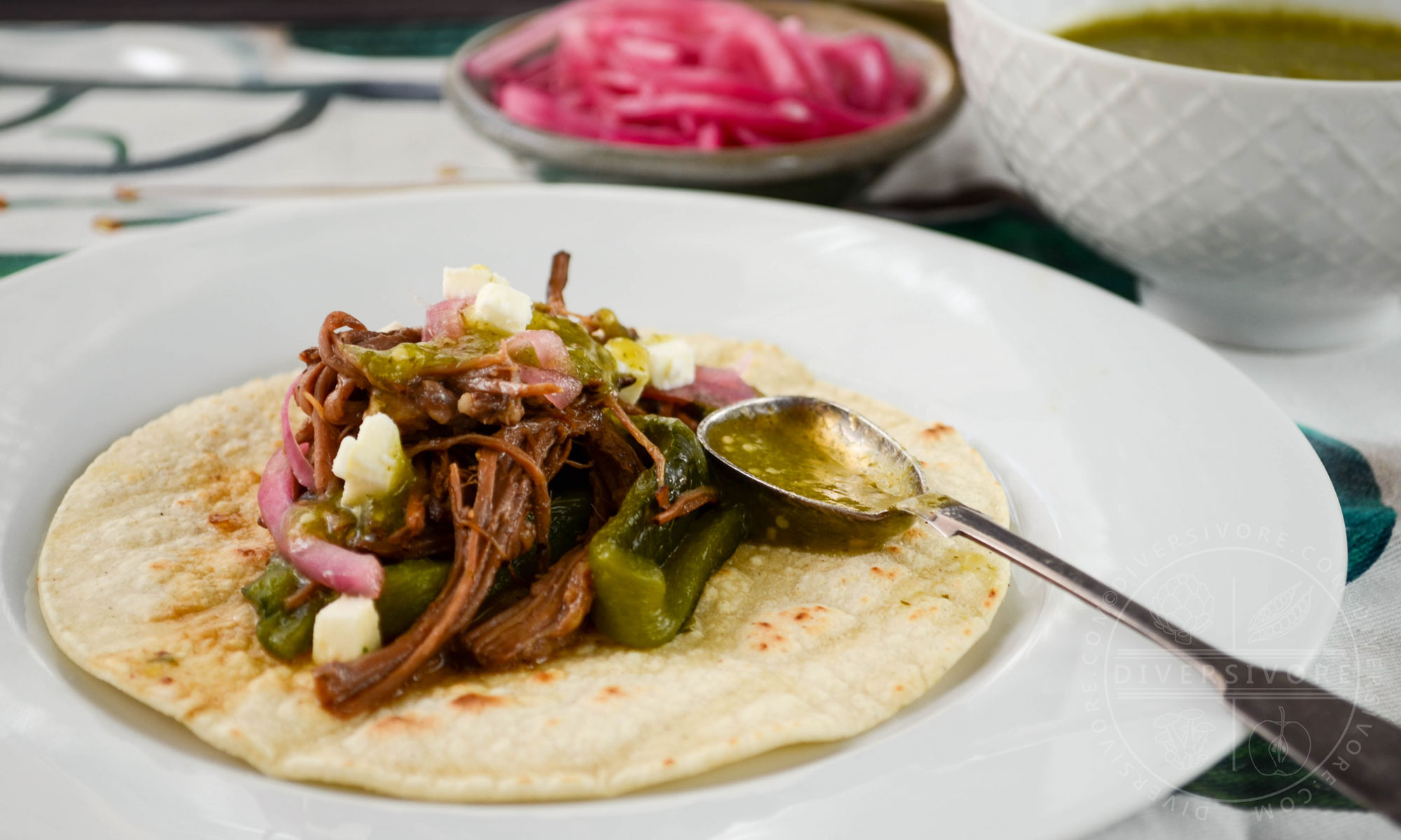 Instant Pot Brisket with Pasilla-Morita Adobo, served in a tortilla with a spoonful of salsa verde