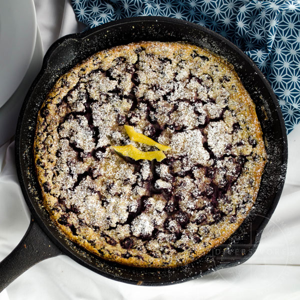Saskatoon berry clafoutis in a cast iron pan, topped with candied lemon peel