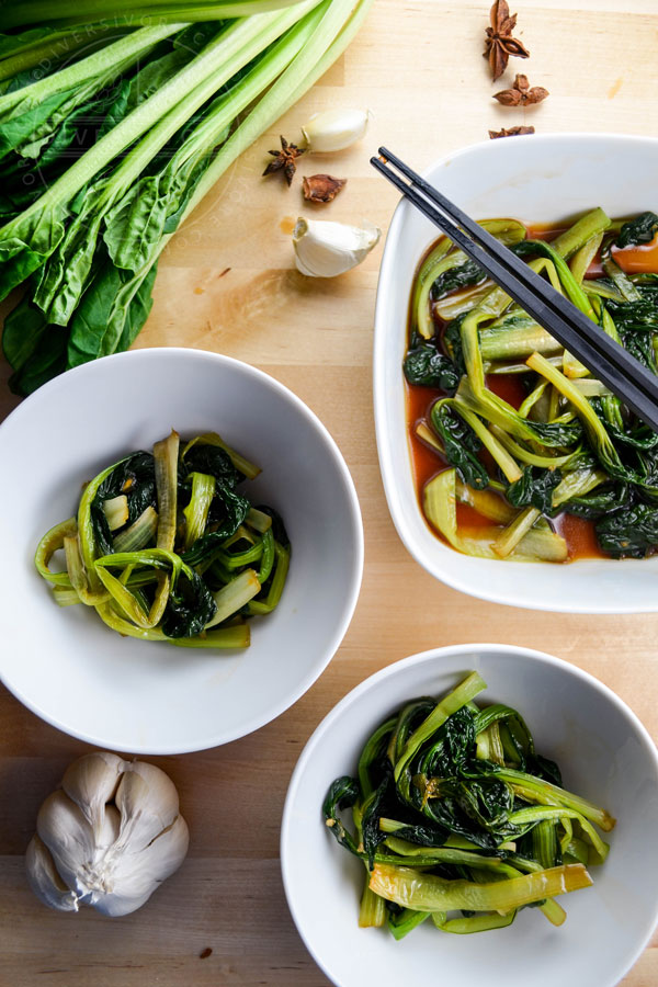 Braised tatsoi (rosette bok choy) in bowls with chopsticks