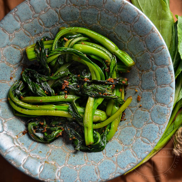 Stir-fried choy sum in a decorative ceramic bowl