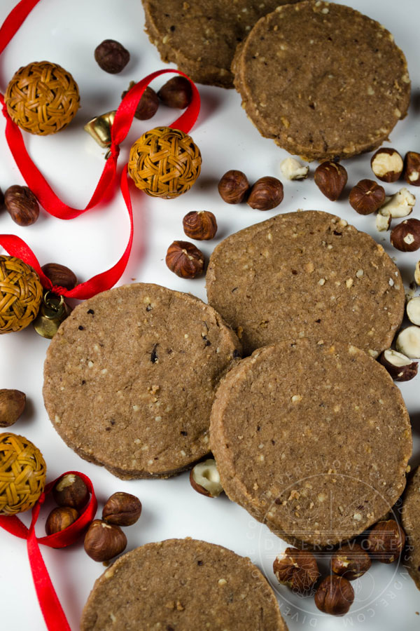 Chocolate Hazelnut Shortbread on a white backdrop with scattered hazelnuts and a red ribbon