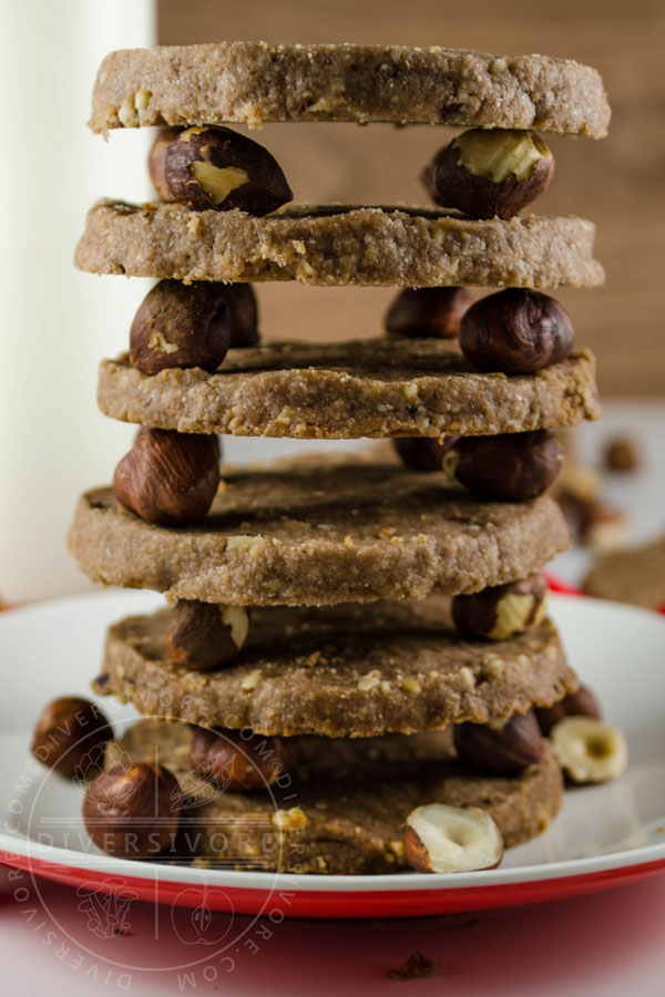 Chocolate Hazelnut Shortbread, made with simple ingredients, and stacked painstakingly on a bunch of hazelnuts.