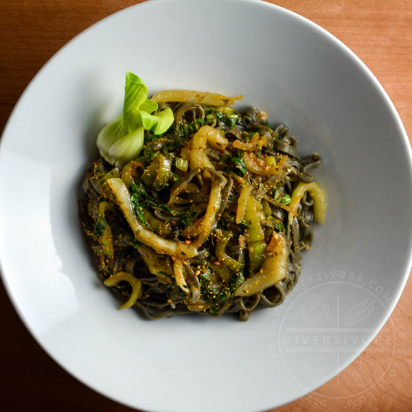 Garlic and lemon bok choy with black sesame noodles in a large white bowl