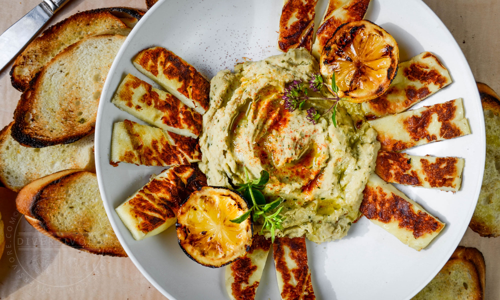 Grilled Halloumi with basil-cannellini hummus, served with grilled lemons and toasted baguette
