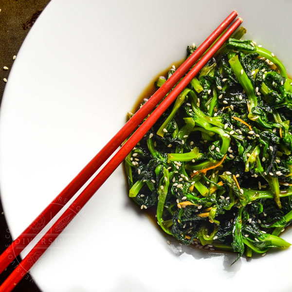 Honey and Ginger Pea Tips with chopsticks in a large white bowl