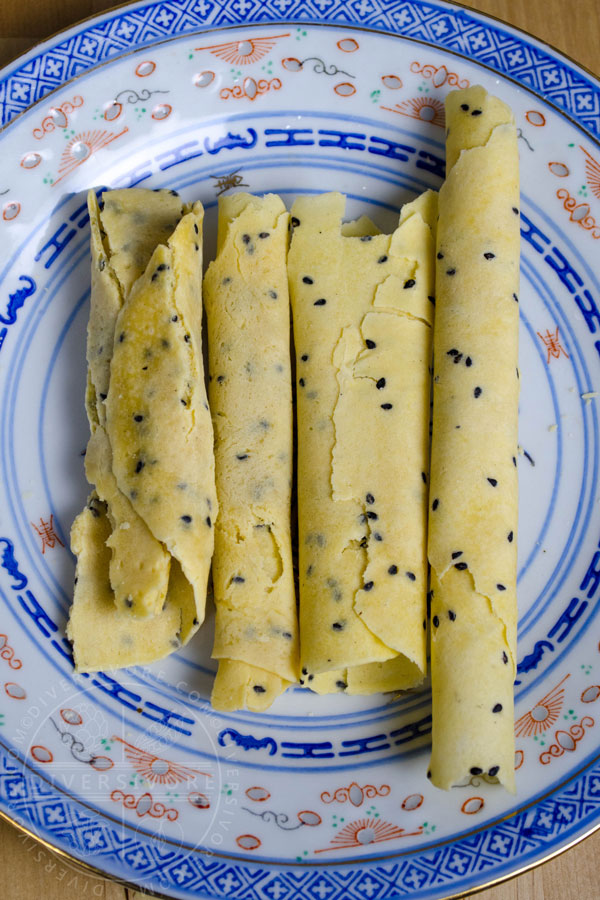 Chinese Crispy Egg Roll (Biscuit Roll) Cookies on a patterned Chinese plate showing various attempts from early (left) to late (right)
