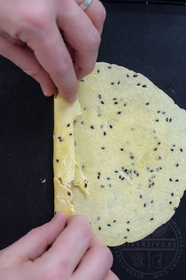 Folding over the cookie and catching any broken bits