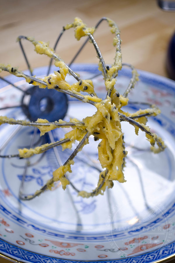 Batter on a whisk on a patterned Chinese plate