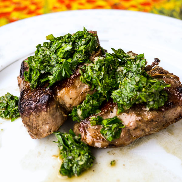 Lamb chop with mint chimichurri on a white plate