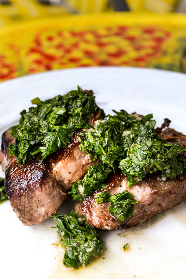 Lamb chop with mint chimichurri on a white plate