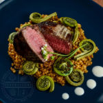 Seared beef tenderloin medallions with simmered einkorn (heirloom wheatberries), sauteed fiddleheads, and a horseradish-yogurt cream - Diversivore.com