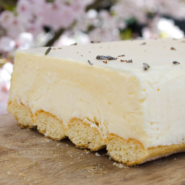 Easy Lemon and Lavender Semifreddo shown on a wood board against a backdrop of cherry flowers